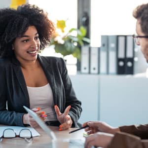 Femme en entretien avec un autre homme autour d'une table