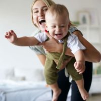 Jeune femme portant un bébé, jouant avec lui